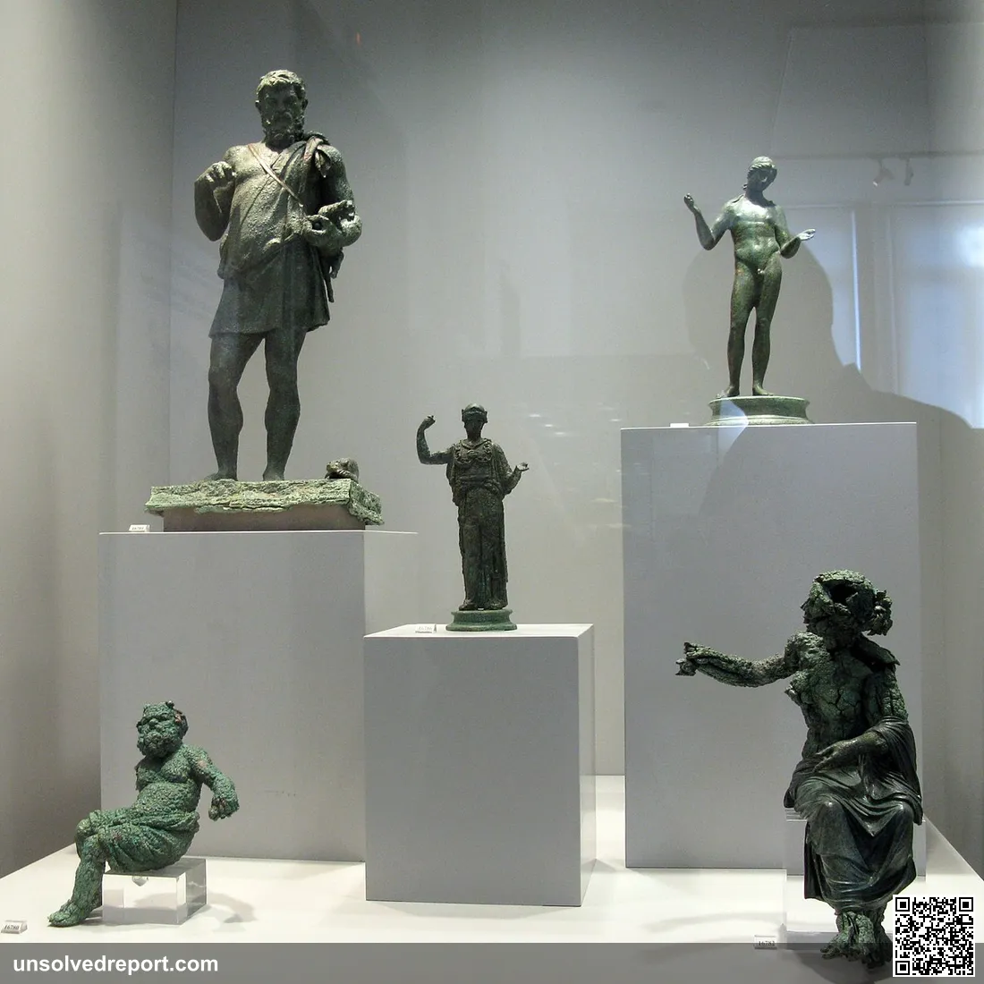 16789: Statuette of a shpard. The figure wears a light tunic leaving one shoulder bare and holds a lamb in the left arm…