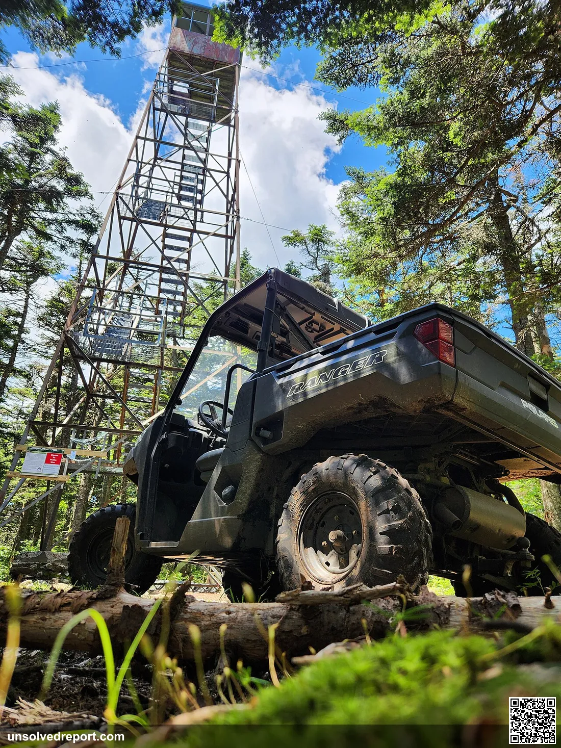 A UTV is parked in front of the Glastenbury Fire Tower with an open sky above. Taken within the Manchester District on …