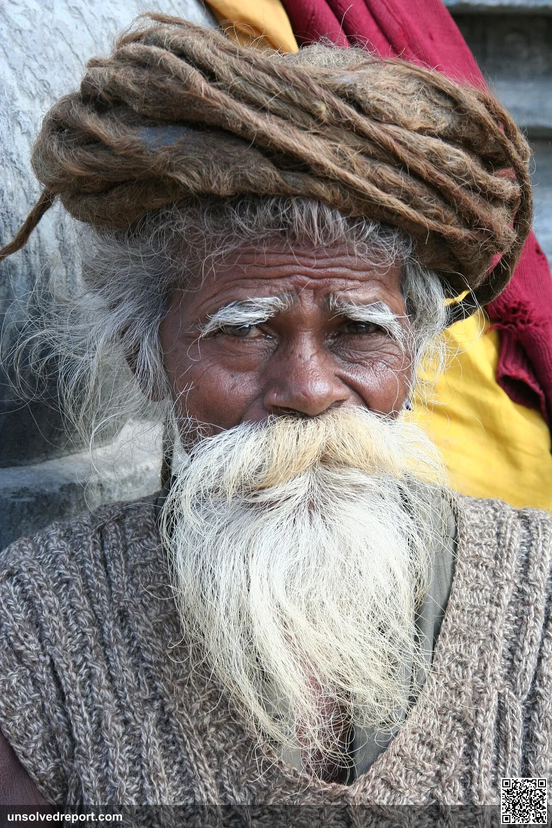 Old sadhu with white beard and coiled dreadlocks in Nepal.